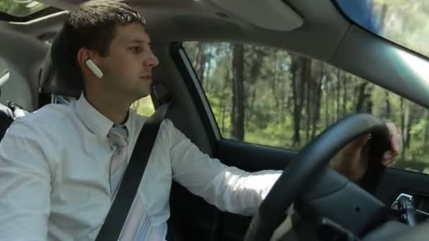 Homem usando mãos dispositivo livre para fazer uma chamada no carro — Vídeo de Stock