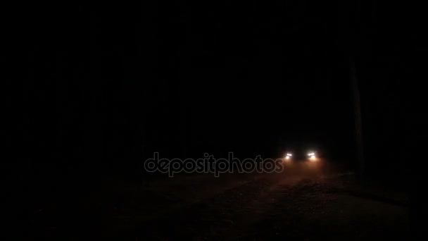Reflektory samochodowe zbliża się na ciemnej drodze — Wideo stockowe