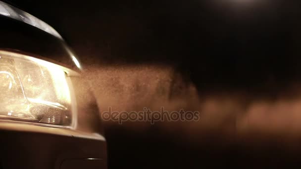 Luces de coche brillantes en las nubes de polvo por la noche — Vídeo de stock