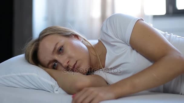 ベッドの枕の上に立てかけられて落ち込んでいる女性 — ストック動画