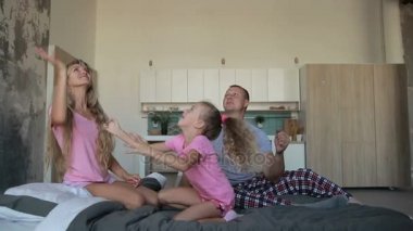 Birlikte yatağa oynayan pijama kaygısız aile