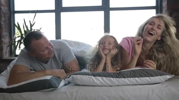 Porträt einer Familie mit Tochter posiert im Bett — Stockvideo