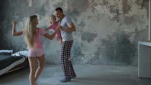 Familia despreocupada con hija bailando en la habitación — Vídeo de stock