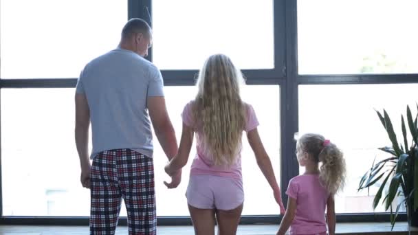 Familia con hija cogida de la mano por la ventana — Vídeos de Stock