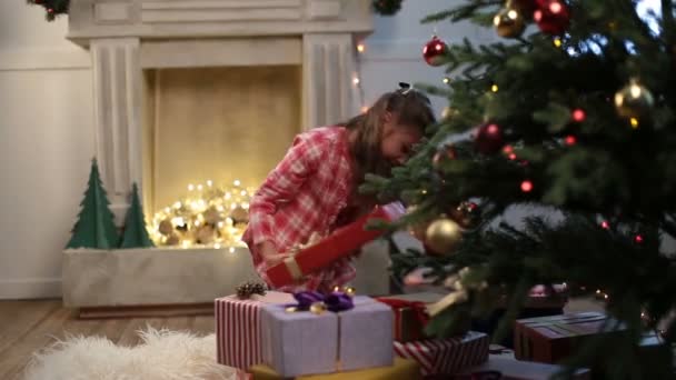 Улыбающаяся девушка с подарочной коробкой на Рождество дома — стоковое видео