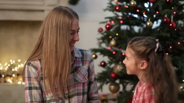 Lilla flickan kysser sin mor vid jul — Stockvideo