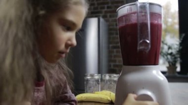 Sevimli kız taze smoothie blender hazırlanıyor