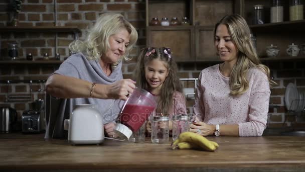 Grandmother pouring berry smoothie into mason jars — Stock Video