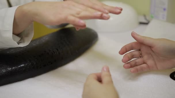 Manicura profesional examinando manos femeninas — Vídeos de Stock