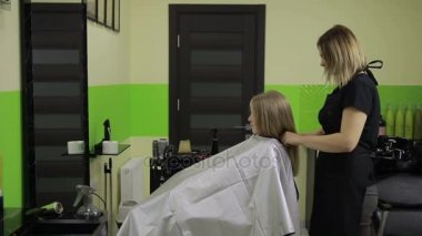 Gülümseyen kız saçlarını kuaförü tarafından sahip