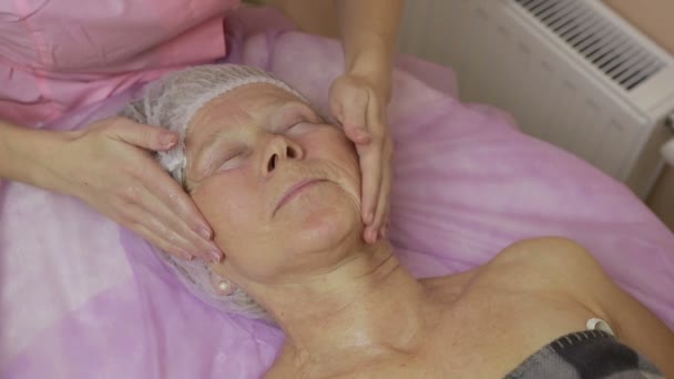 스파 얼굴 치료를 받고 편안한 노인 여성 — 비디오
