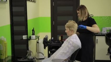 Güzellik uzmanı tarafından boyalı saçları olan kadın kıdemli