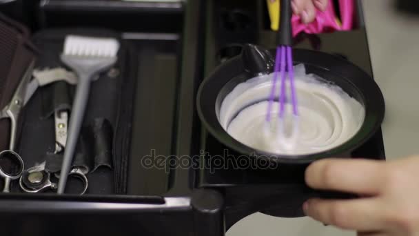 Peluquería mezclando tinte para el cabello en un tazón en una peluquería — Vídeo de stock