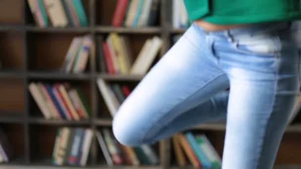 Vysokoškolský student nesoucí hromadu knih v knihovně — Stock video