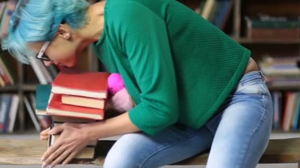 Hipster estudiante mujer studiyng duro en la biblioteca — Vídeos de Stock