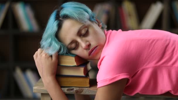 Estudiante agotada durmiendo en un montón de libros — Vídeos de Stock