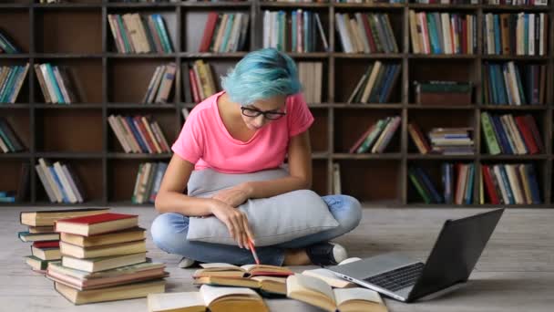 Estudante do sexo feminino pesquisando com livros e laptop — Vídeo de Stock