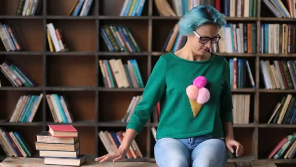 Zorgeloos vrouwelijke student met behulp van telefoon in bibliotheek — Stockvideo