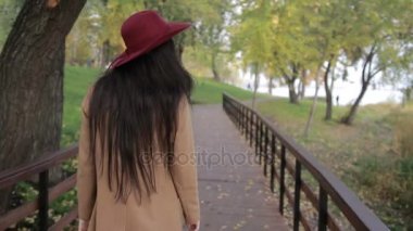 Park ahşap köprü üzerinde yürüyen son moda kadın