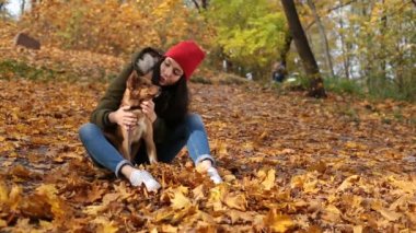 Güzel kız okşayarak sevimli köpek sonbahar Park