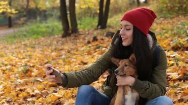 Gülümseyen kadın köpekle selfie sonbaharda alarak