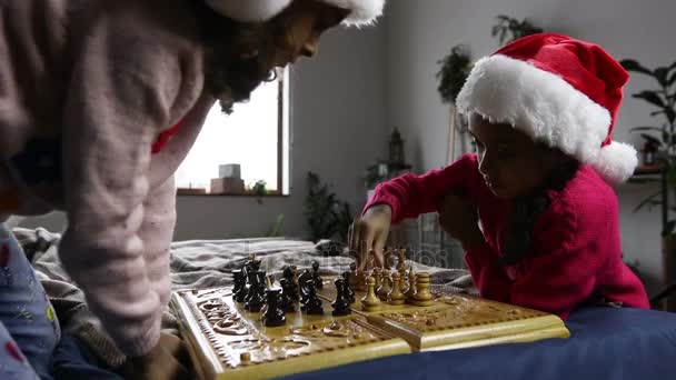 Dos chicas inteligentes moviendo piezas de ajedrez en el tablero de ajedrez — Vídeos de Stock