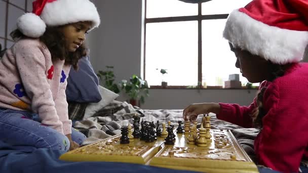 Два молодых шахматиста в шляпах Санты в помещении — стоковое видео