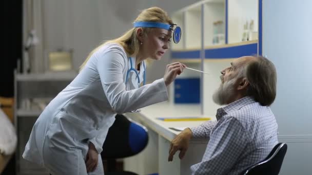 Arzt untersucht Kehle mit Zungendepressor — Stockvideo