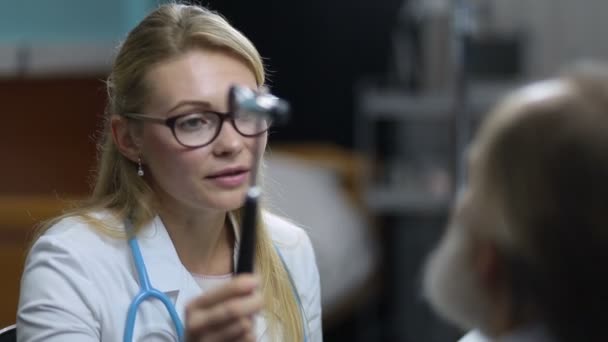 Neurólogo femenino prueba reflejos del ojo de la paciente — Vídeos de Stock