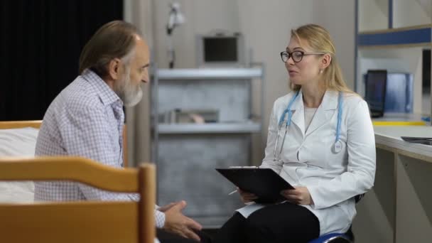 Врач рассказывает пациенту хорошие медицинские результаты — стоковое видео