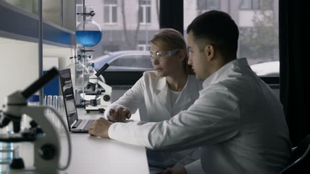 Científicos profesionales discutiendo investigación en laboratorio — Vídeo de stock