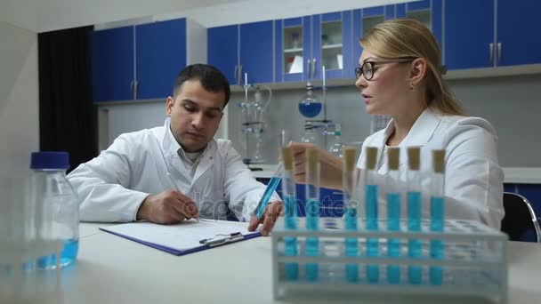 Científicos confiados examinan solución en laboratorio — Vídeos de Stock