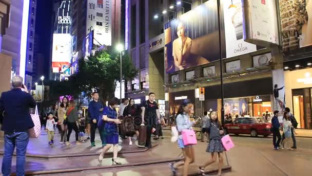 Pedestres cruzando rua comercial à noite — Vídeo de Stock