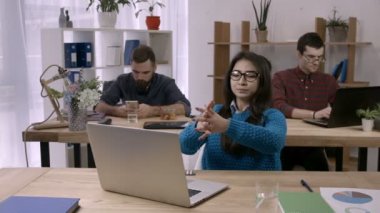 Geçici iş kadını ofiste masasında germe
