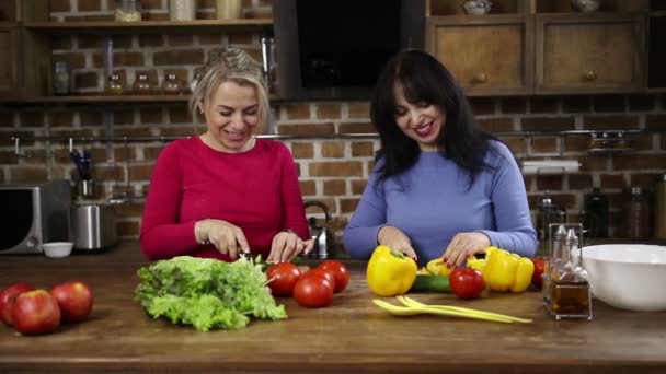 笑顔の女性が台所で野菜をカット — ストック動画