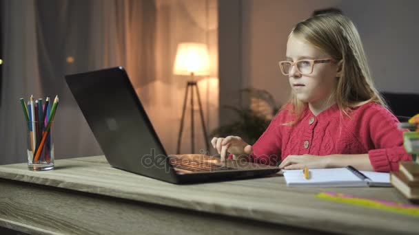 Cheerful child doing homework online with laptop — Stock Video