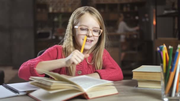 Cheerful girl writing her homework for school — Stock Video