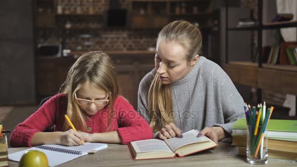 Mother helping her daughter with homework at home — Stock Video