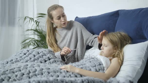 Mama, sprawdzanie temperatury nastoletnie córki w łóżku — Wideo stockowe