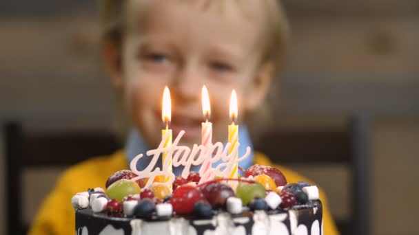 Detail o chlapce foukání svíčky na narozeninový dort