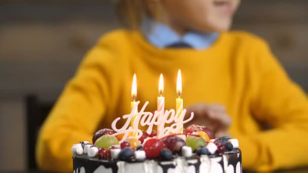 ケーキの上の蝋燭を吹く幼児男の子の中央部 — ストック動画