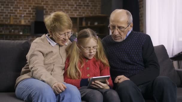 Chica adolescente enseñando a los abuelos a usar touchpad — Vídeos de Stock