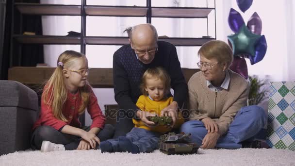 Granfather teaching boy to use radio control toy — Stock Video