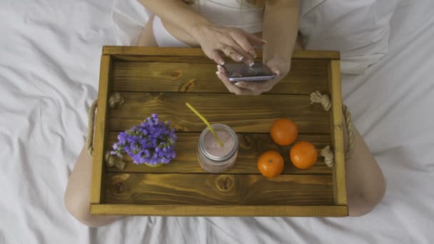 Vue du dessus de la femme avec smartphone et smoothie — Video