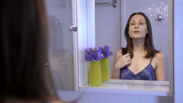 Půvabná brunetka líbí její pohled do zrcadla — Stock video