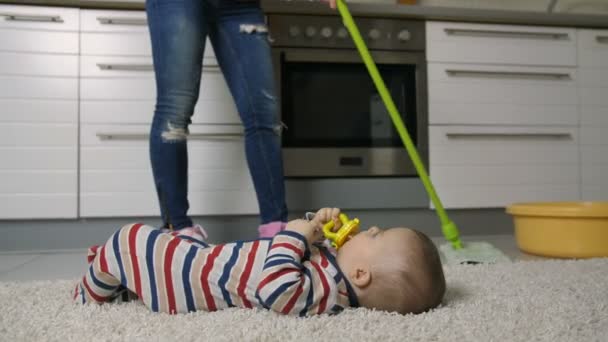 아기와 함께 바닥을 청소 하는 여성 다리의 클로즈업 — 비디오