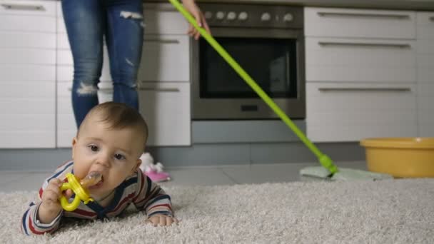 Close-up van dames benen reiniging van de vloer in de buurt van baby — Stockvideo