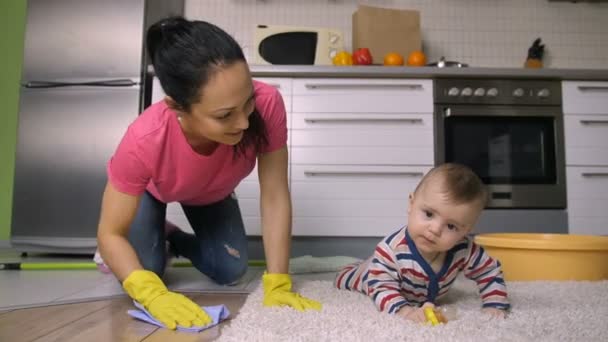 Madre latina de rodillas fregando piso con bebé — Vídeos de Stock