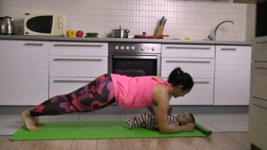 Sportif anne öpüşme bebek tahta egzersiz yaparak