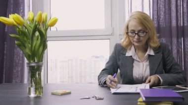 Belgeler üzerinde çalışan Kıdemli Emlak Ajan